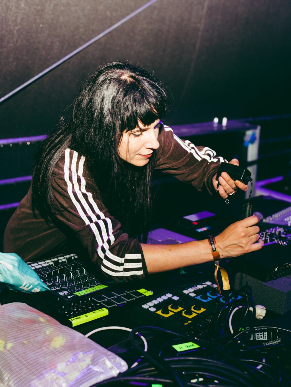 A woman preparing the technical setup for her electronic live act.